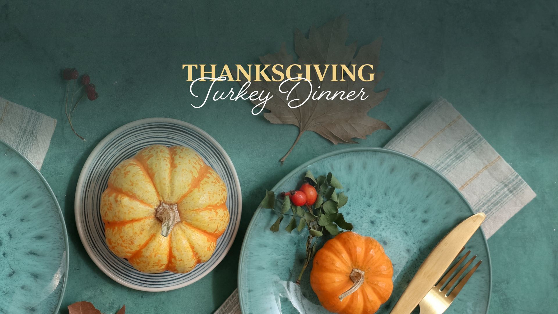 Thanksgiving turkey dinner with roasted squash, pumpkin, and plates on a teal tablecloth