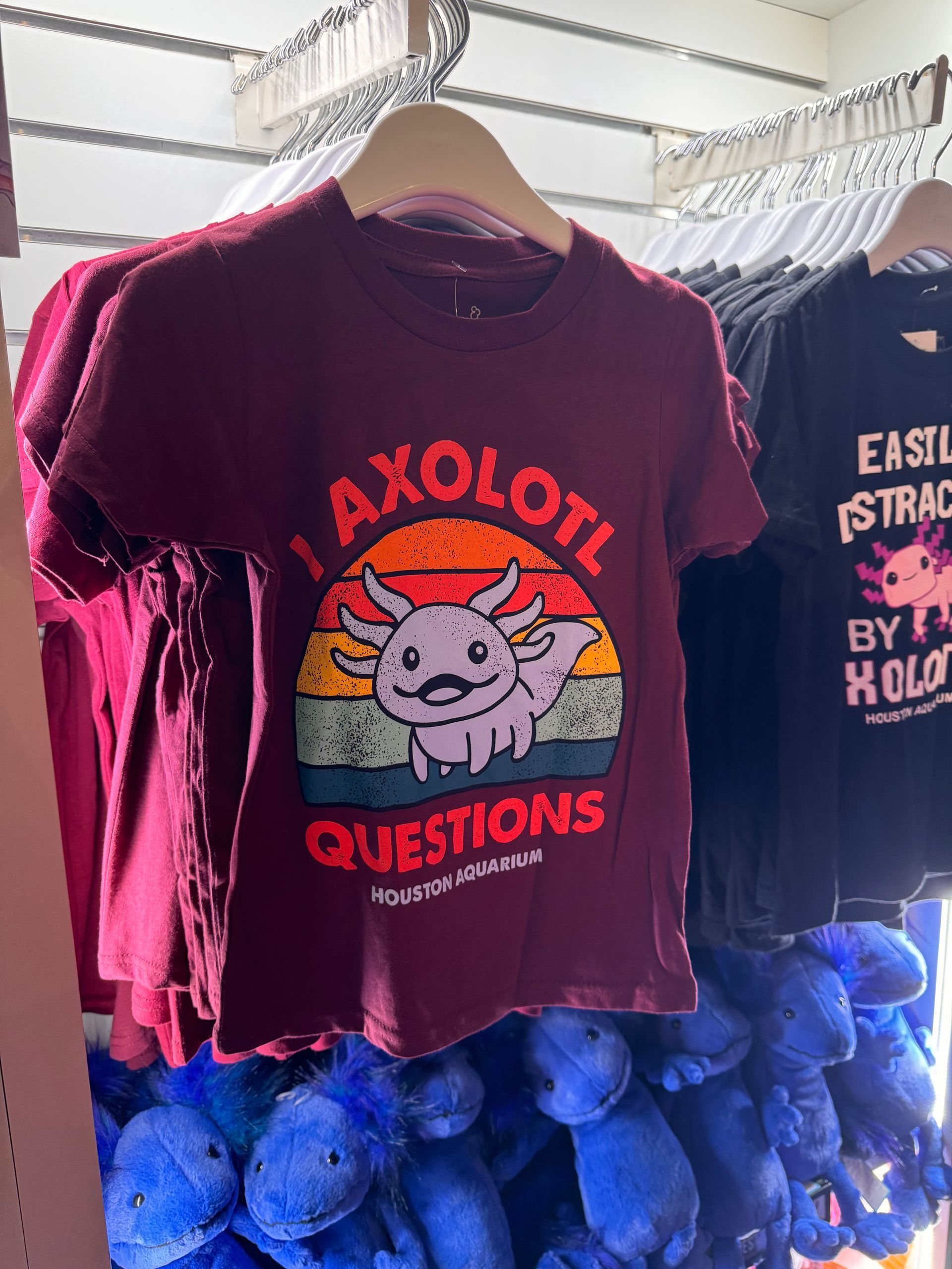 A maroon t-shirt with an axolotl on it