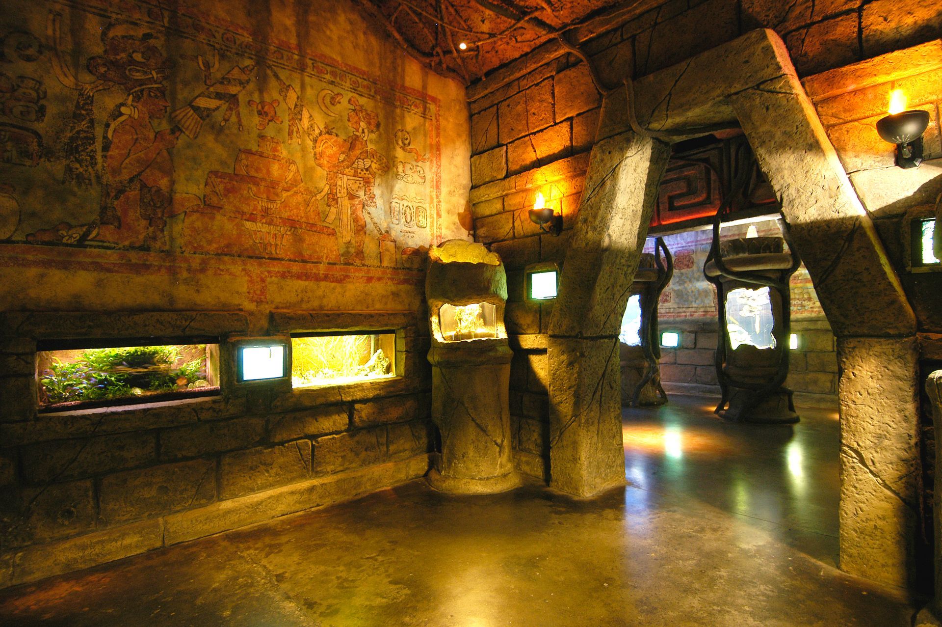 A room with a lot of bricks and a painting on the wall and aquariums