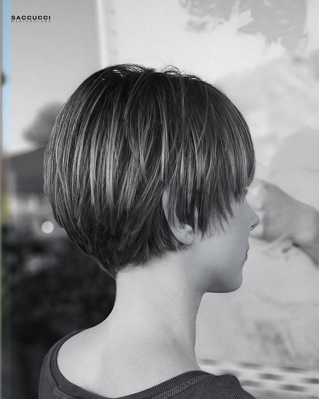 Vista di profilo di una persona con un taglio di capelli corto, scalato e scuro, caratterizzato da volume nella parte posteriore.