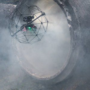 Un drone vole à travers un tuyau et de la fumée en sort.