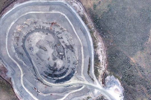 Une vue aérienne d'une grande formation rocheuse traversée par une route.
