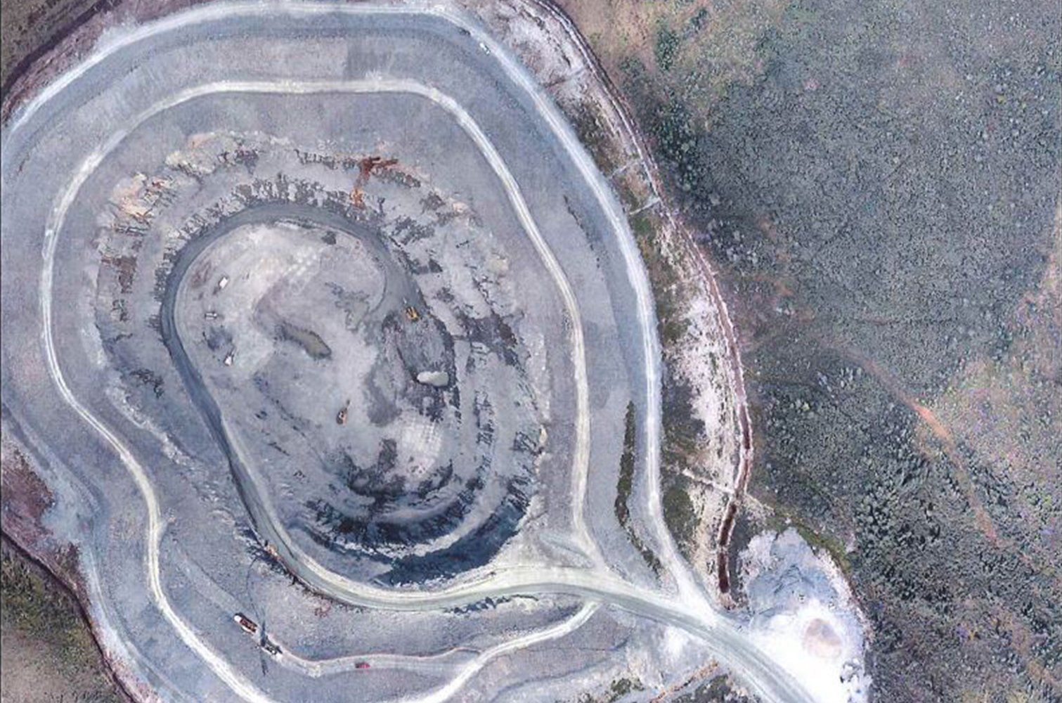 Une vue aérienne d'une grande formation rocheuse avec une route qui la traverse.