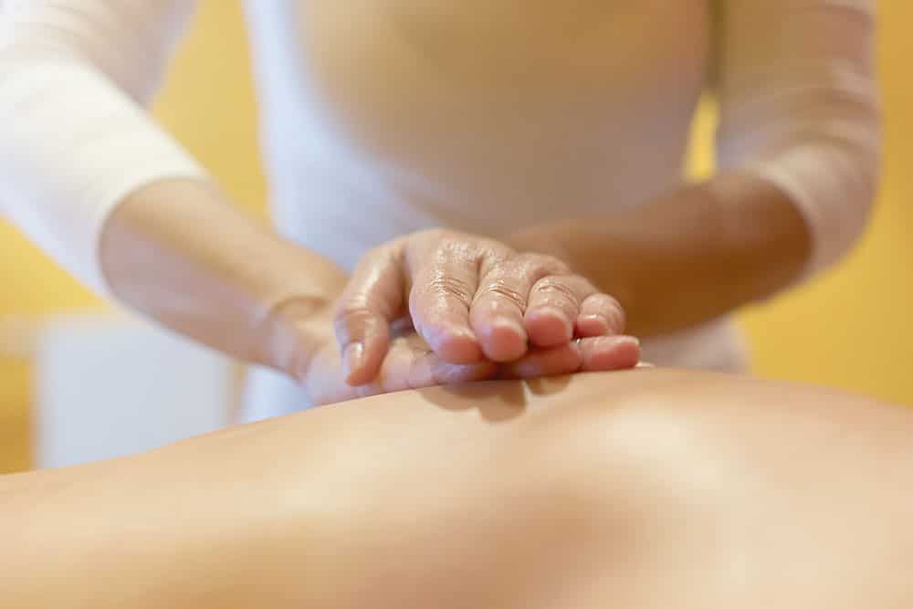 Hands On Back Of Patient