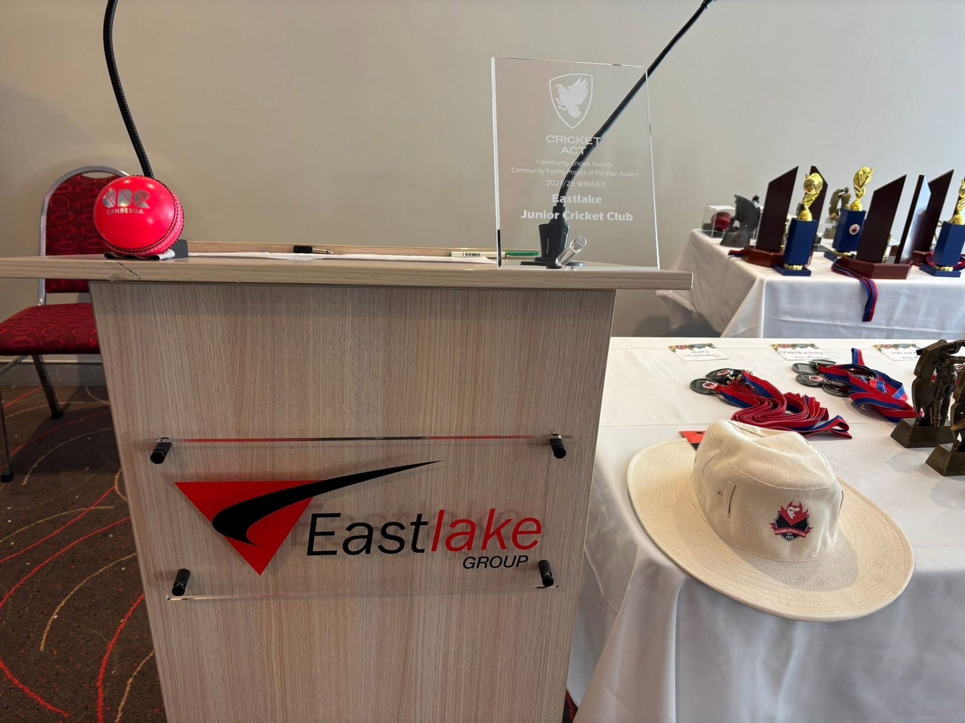 Eastlake Church podium on stage with microphone, communion trays, and hats displayed nearby