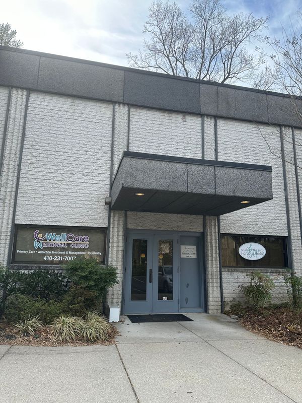 A large brick building with a blue door and a canopy over the entrance.