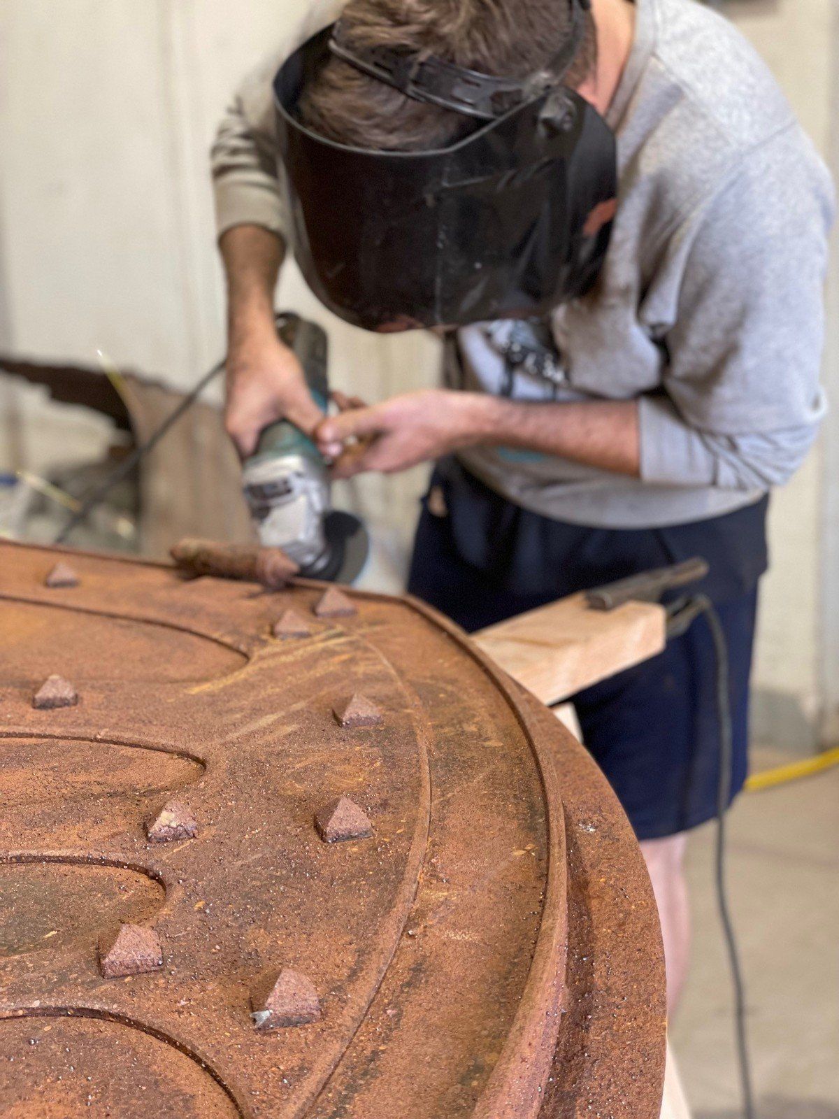 Craftsman grinding metal on a winery tasting room door.