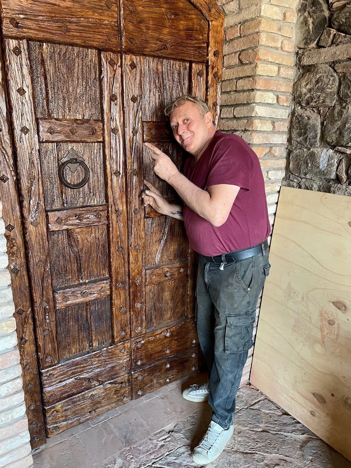 Giorgio standing with a newly installed farmhouse door at the castle.