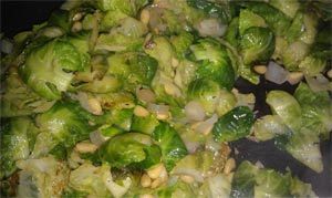 Brussels sprouts, sautéed with what appears to be pine nuts and onion.