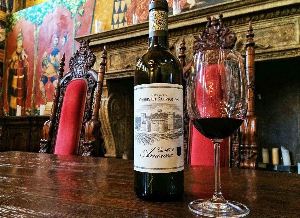 Cabernet Sauvignon bottle and glass with ornate backdrop