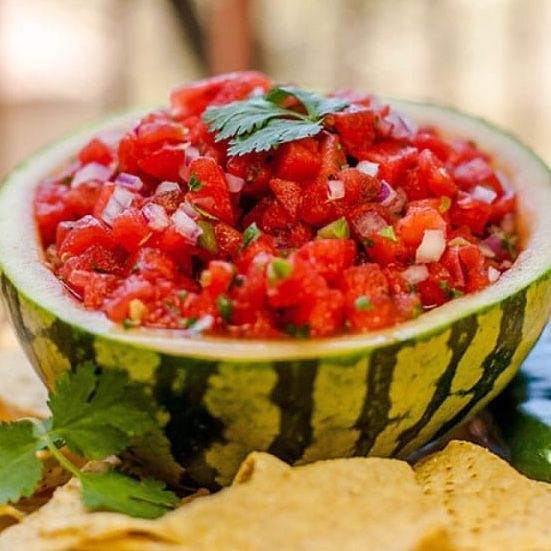 Watermelon salsa in a watermelon rind bowl with tortilla chips.