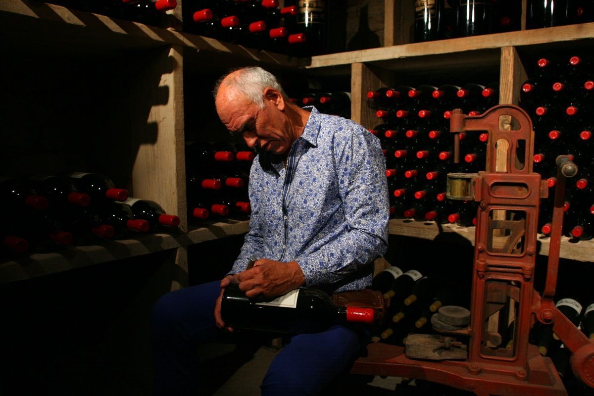 Dario Sattui signing wine bottles