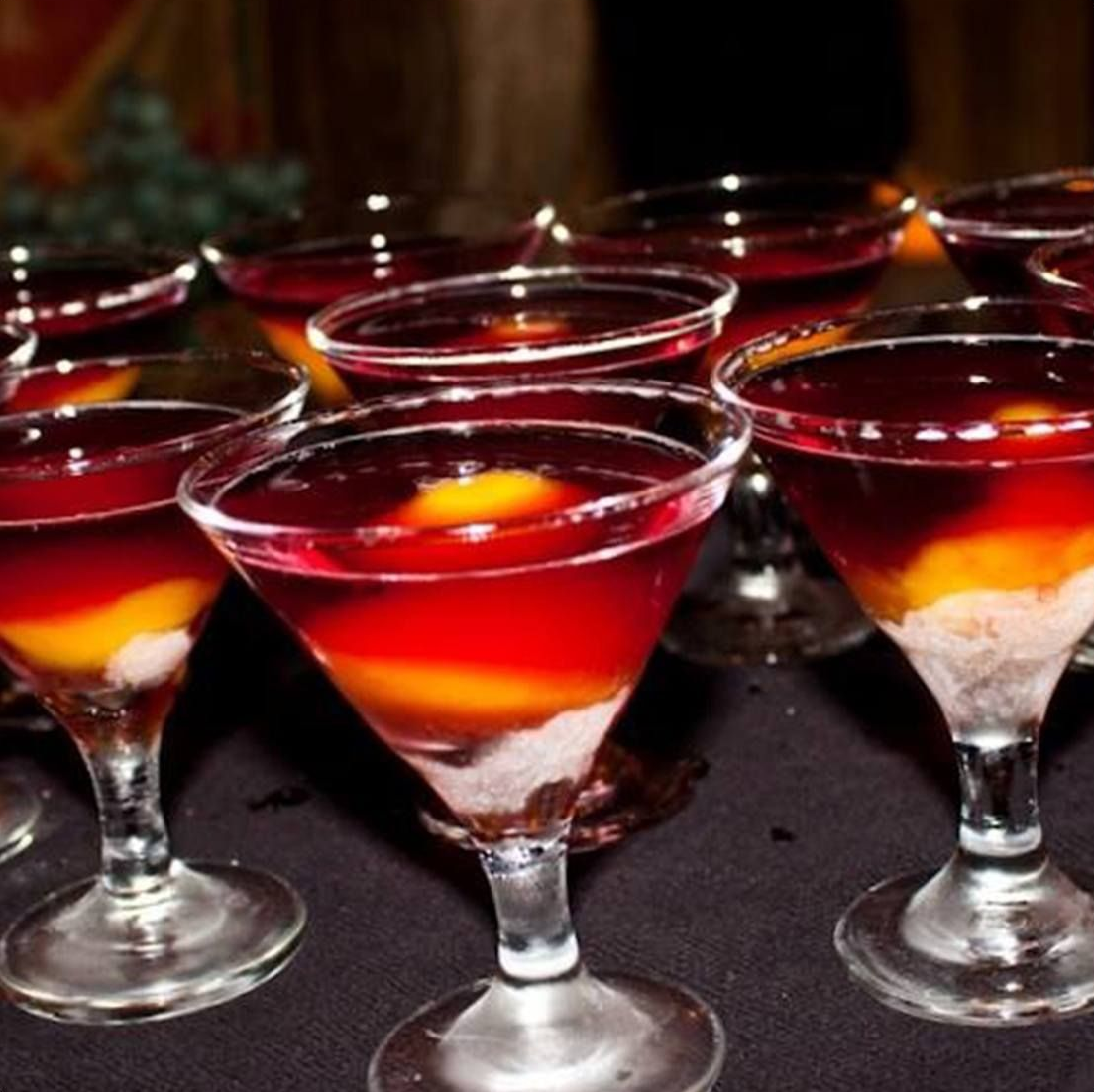 Martini glasses filled with layered red and yellow cocktails.