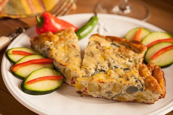 Slices of frittata plated with vegetables