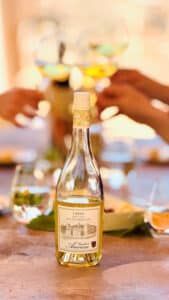 Bottle of Libero Moscato on a table with people toasting in the background.