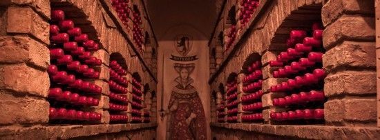 a statue in a doorway with red grapes in front of it