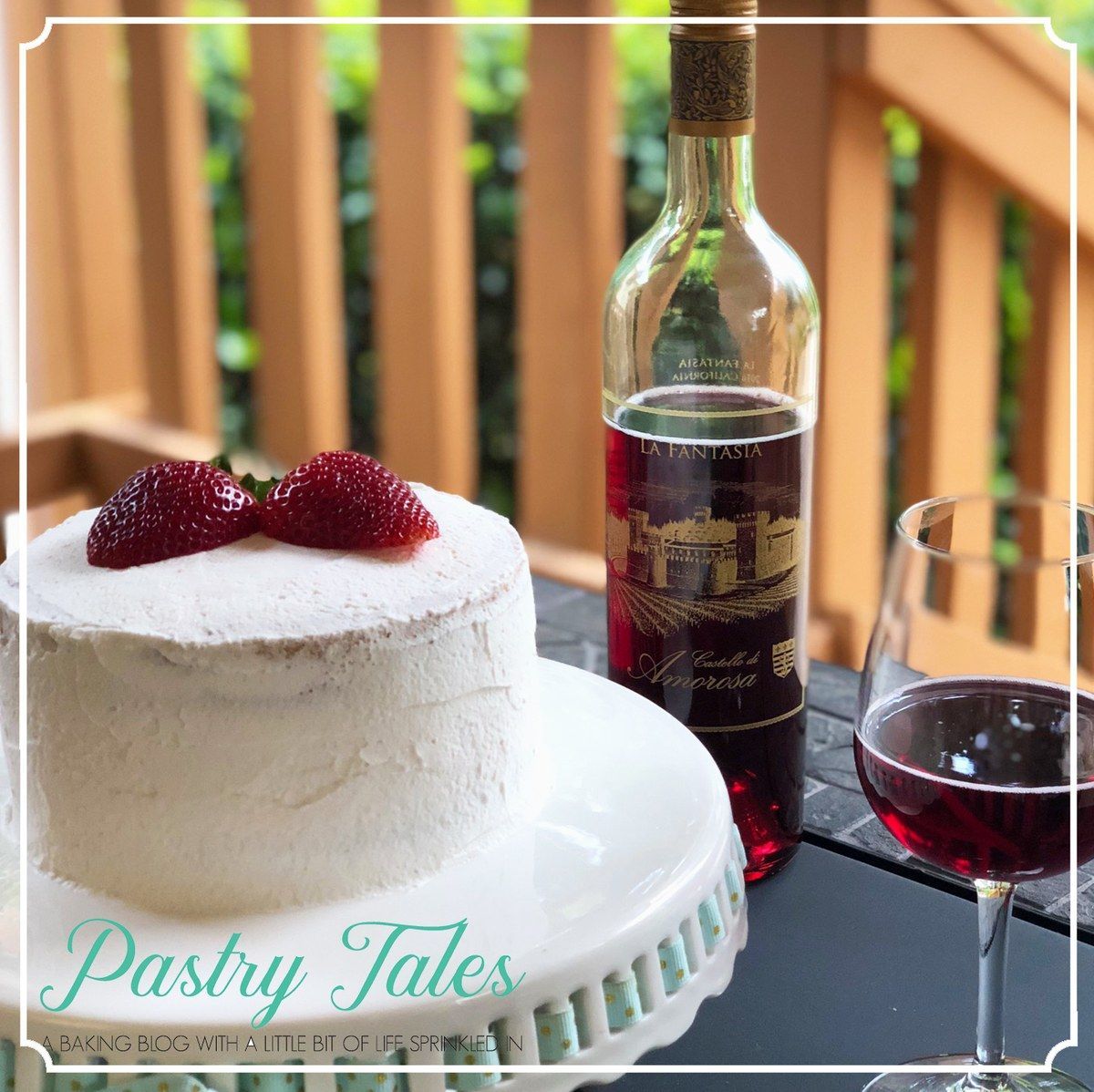 Cake with strawberries, wine bottle, and glass on a table. Outdoor setting.