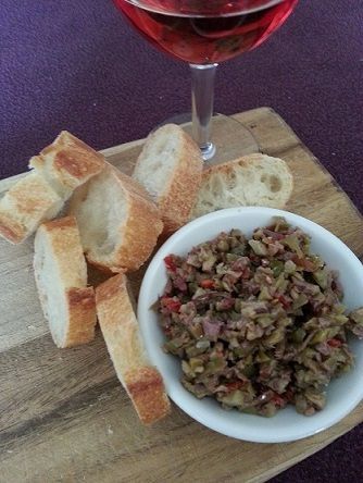 Bread with olive tapenade and wine on a wooden board