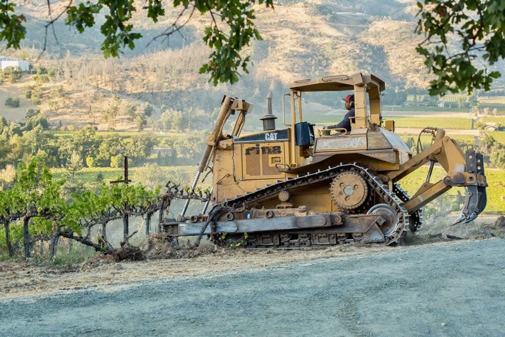 Massive tractor removing vines from the vineyard.