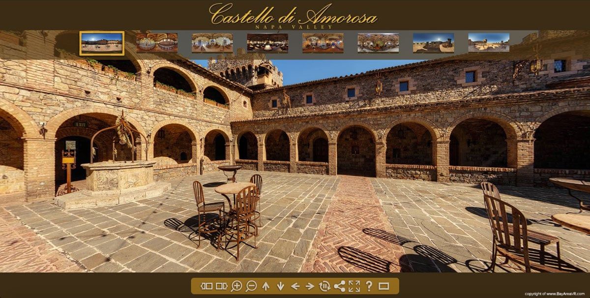 Courtyard of the Castello di Sammezzano, with stone arches, well, tables, and chairs.