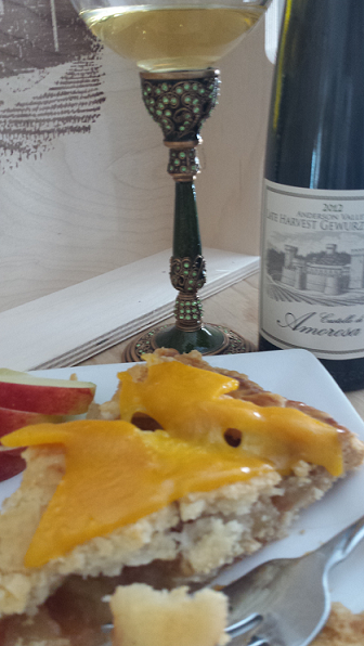 Cheese plate with apple slices and a glass of white wine