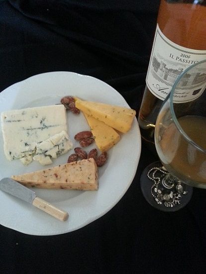 Cheese board with blue cheese, nuts, wine bottle and glass