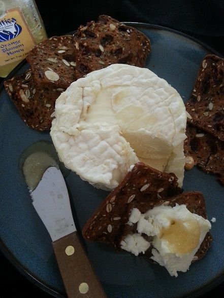 Brie cheese with crackers, honey, and cheese knife