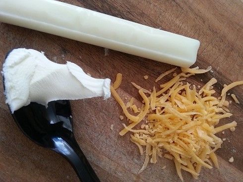 Assorted cheeses including string cheese, shredded cheddar, and cream cheese