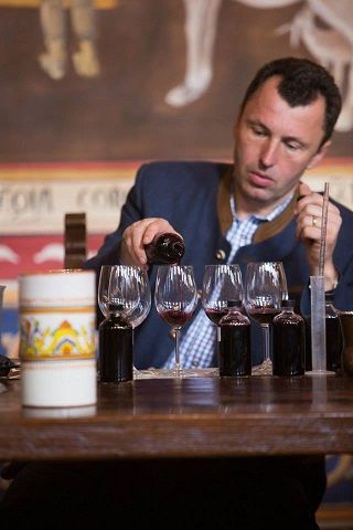 Man pouring red wine into a glass during tasting