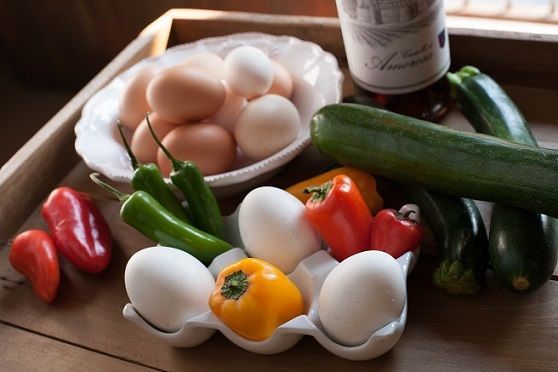 Fresh eggs and vegetables arranged for cooking frittata