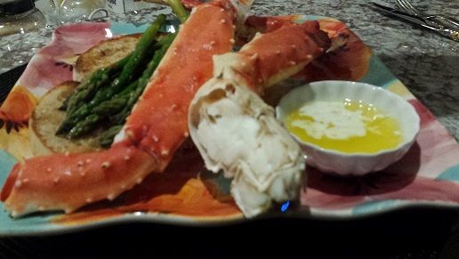 King crab legs with asparagus and toast served on colorful plate