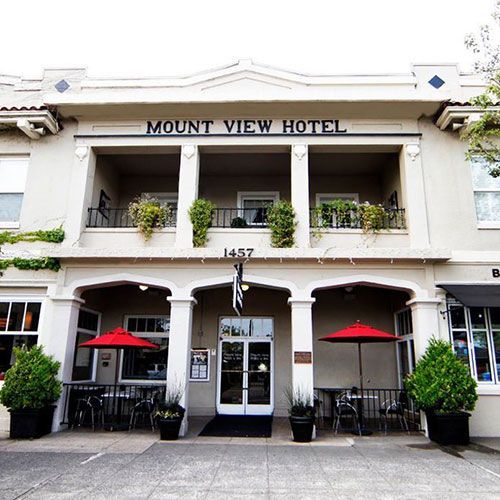 Mount View Hotel, a two-story building with a covered entrance, red umbrellas, and potted plants.