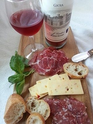 Charcuterie board with bread, cheese, meats, and wine