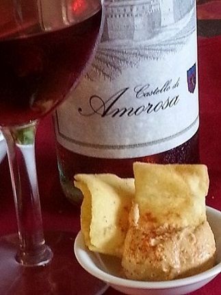 Wine with crackers and dip on a red surface