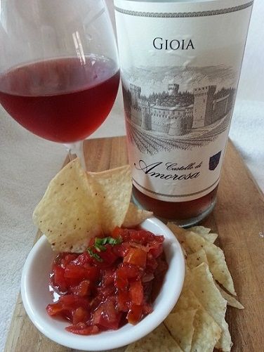 Wine, salsa, and tortilla chips on a wooden board
