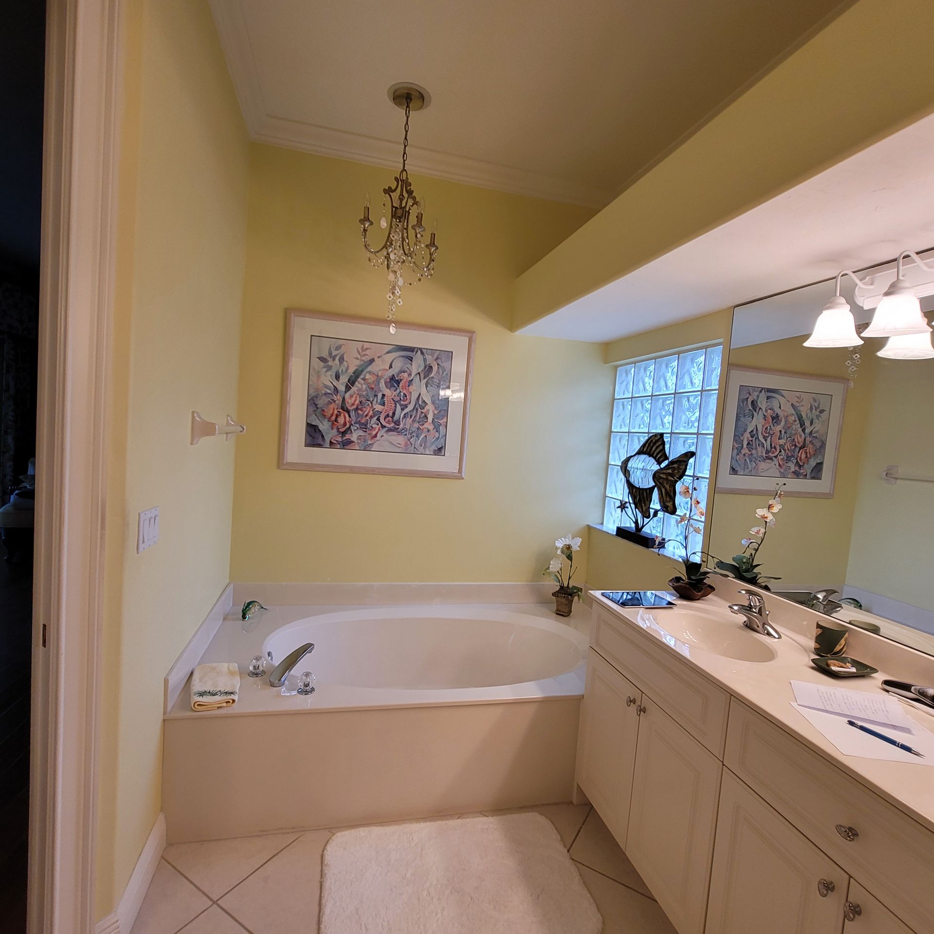 A bathroom with a tub a sink and a mirror.