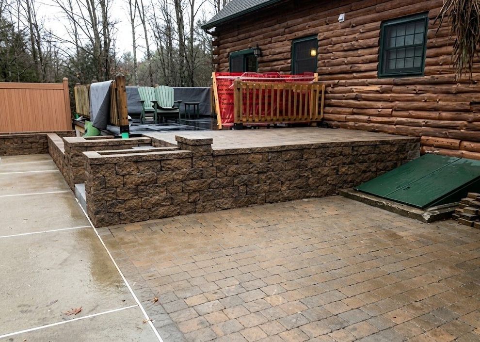 Natural stone retaining wall on a Maine residential property at golden hour