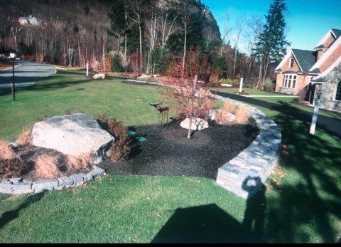 Complete outdoor living space with stone patio, walkway, and retaining wall