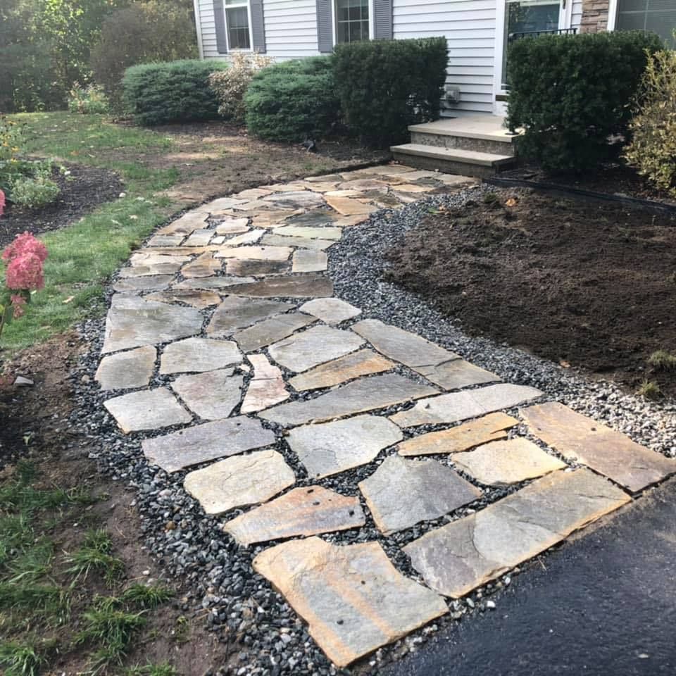 Contractor resetting displaced flagstone pavers