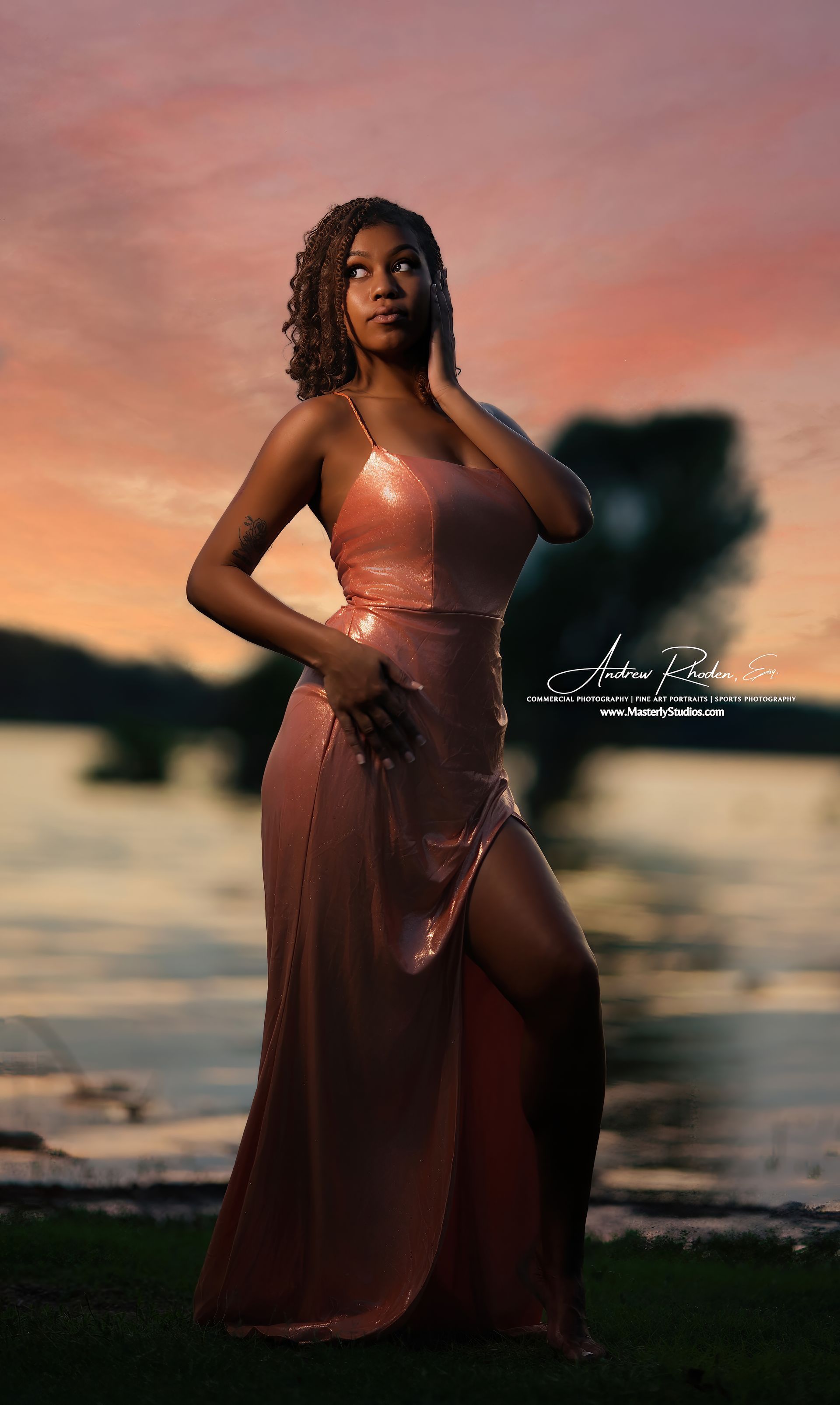 Woman in a shimmering rose gown posing at sunset by the water