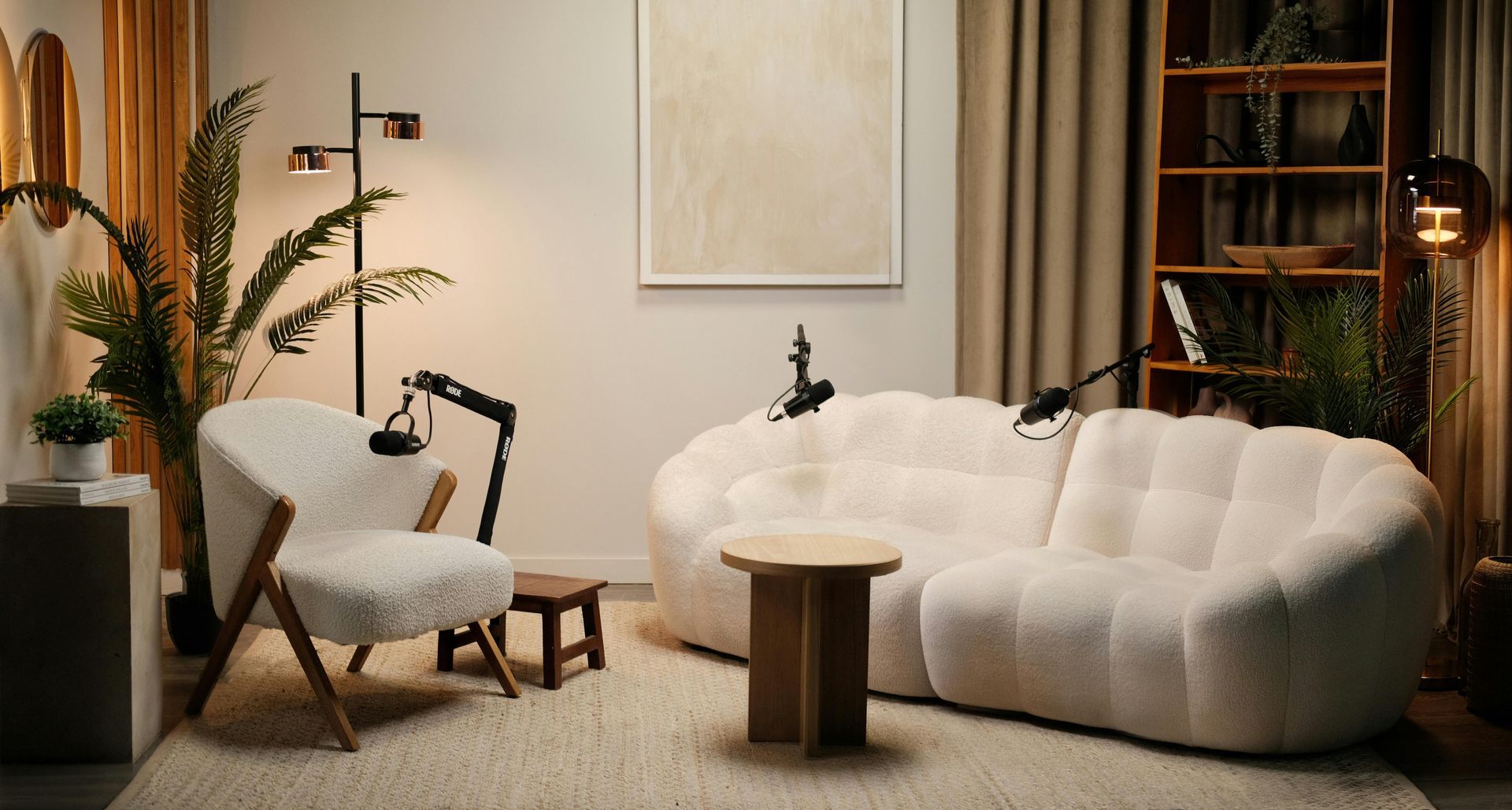 Cozy beige living room with white sofa, accent chair, plants, and warm ambient lighting