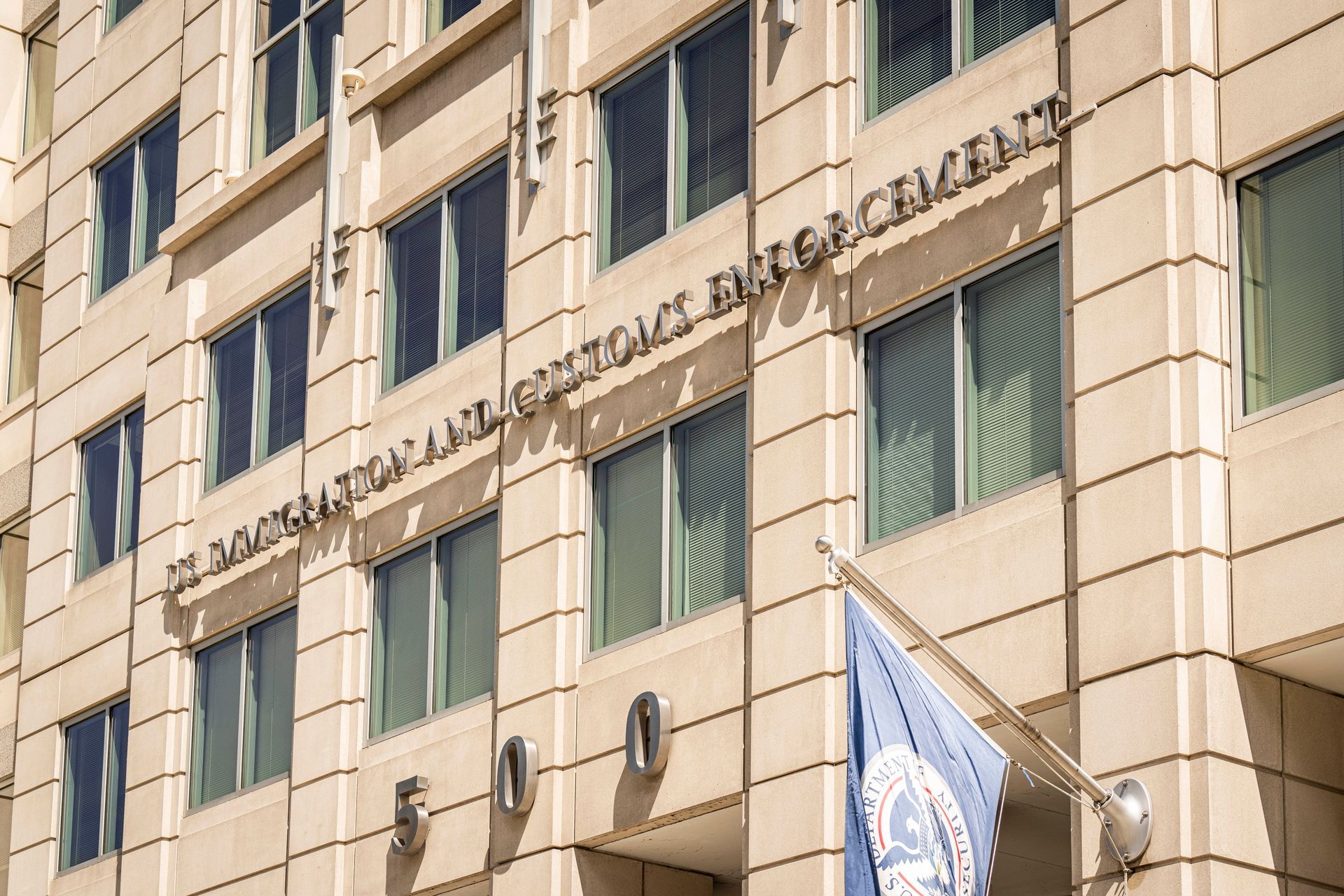 Building facade with “National School of Economics” signage and a blue UN flag hanging outside