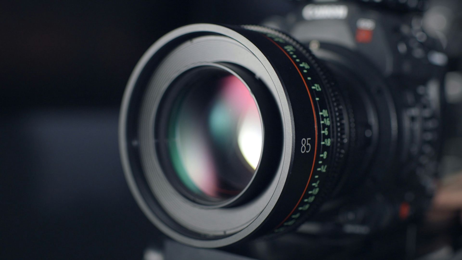 Close-up of a camera lens with blurred camera body in the background