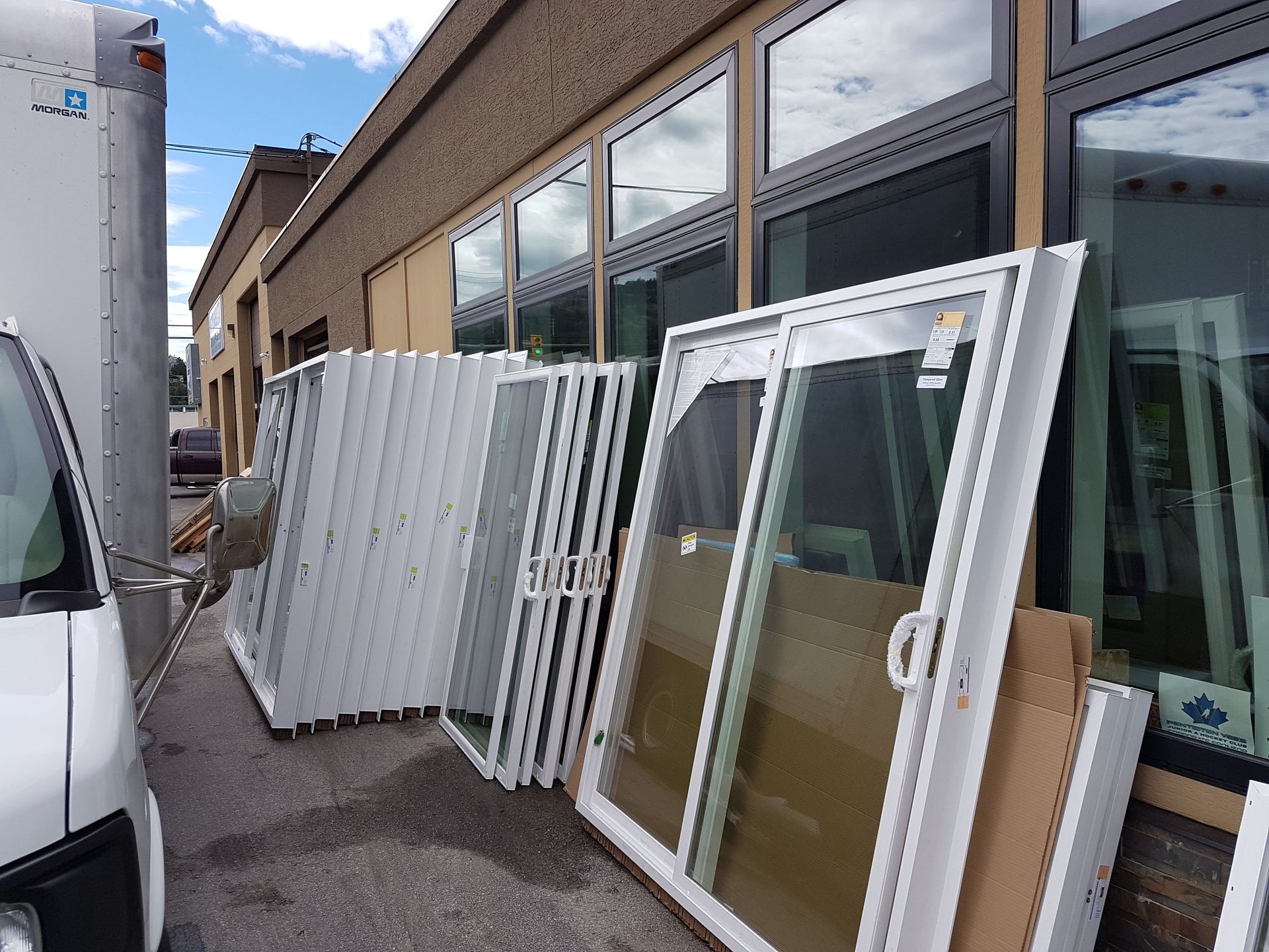 White French doors stacked in front of a commercial building with glass windows.