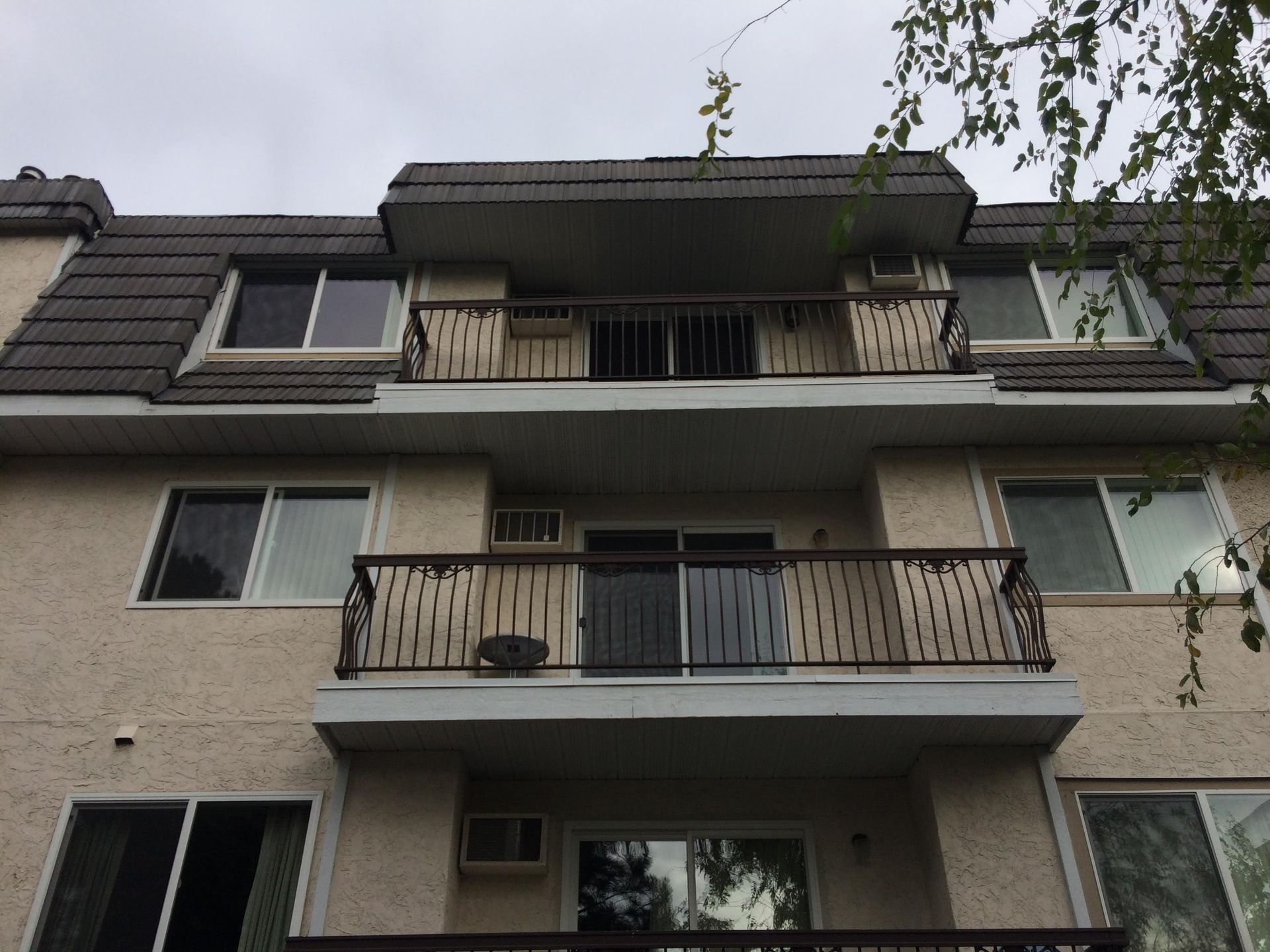 Three-story residential building with balconies and replacement windows.