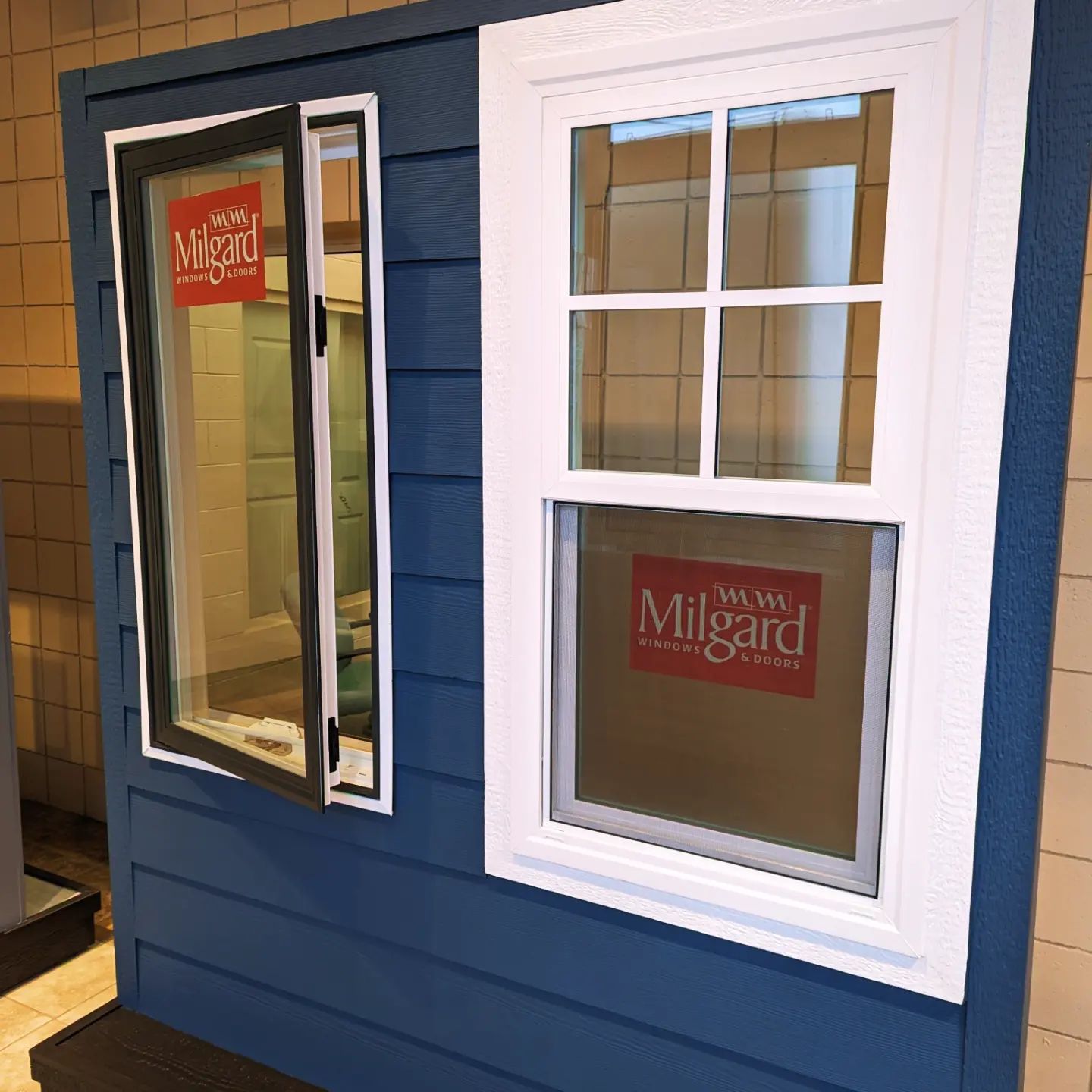Blue wall with two demonstration windows: a narrow casement window on the left and a large grid window on the right.