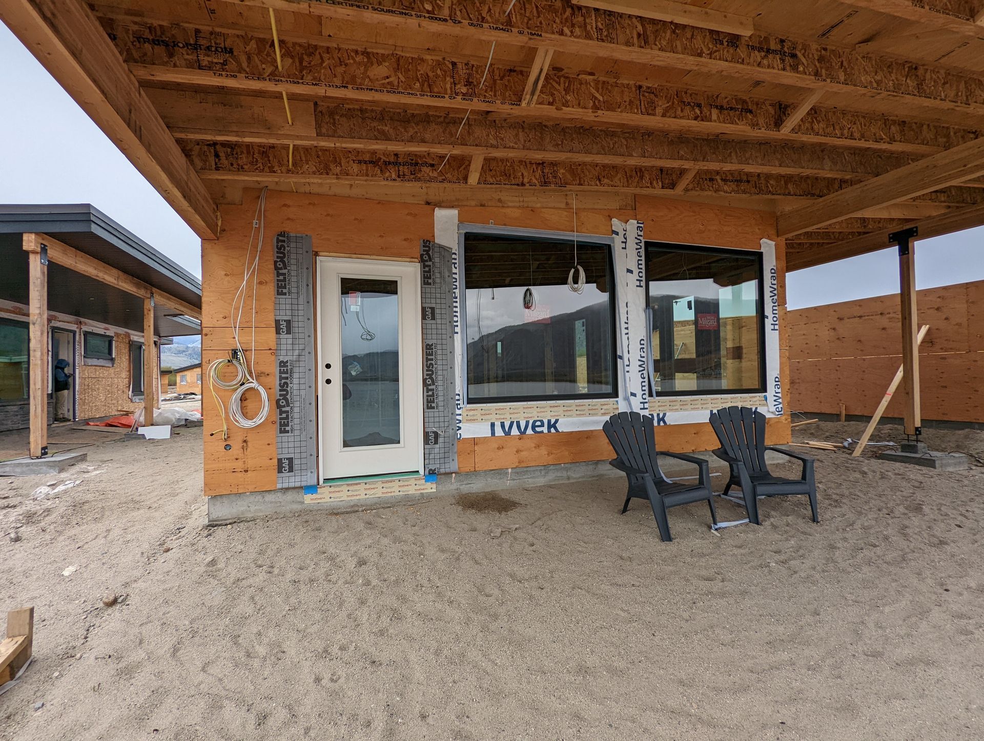 Wooden-framed windows being installed on a house under construction.