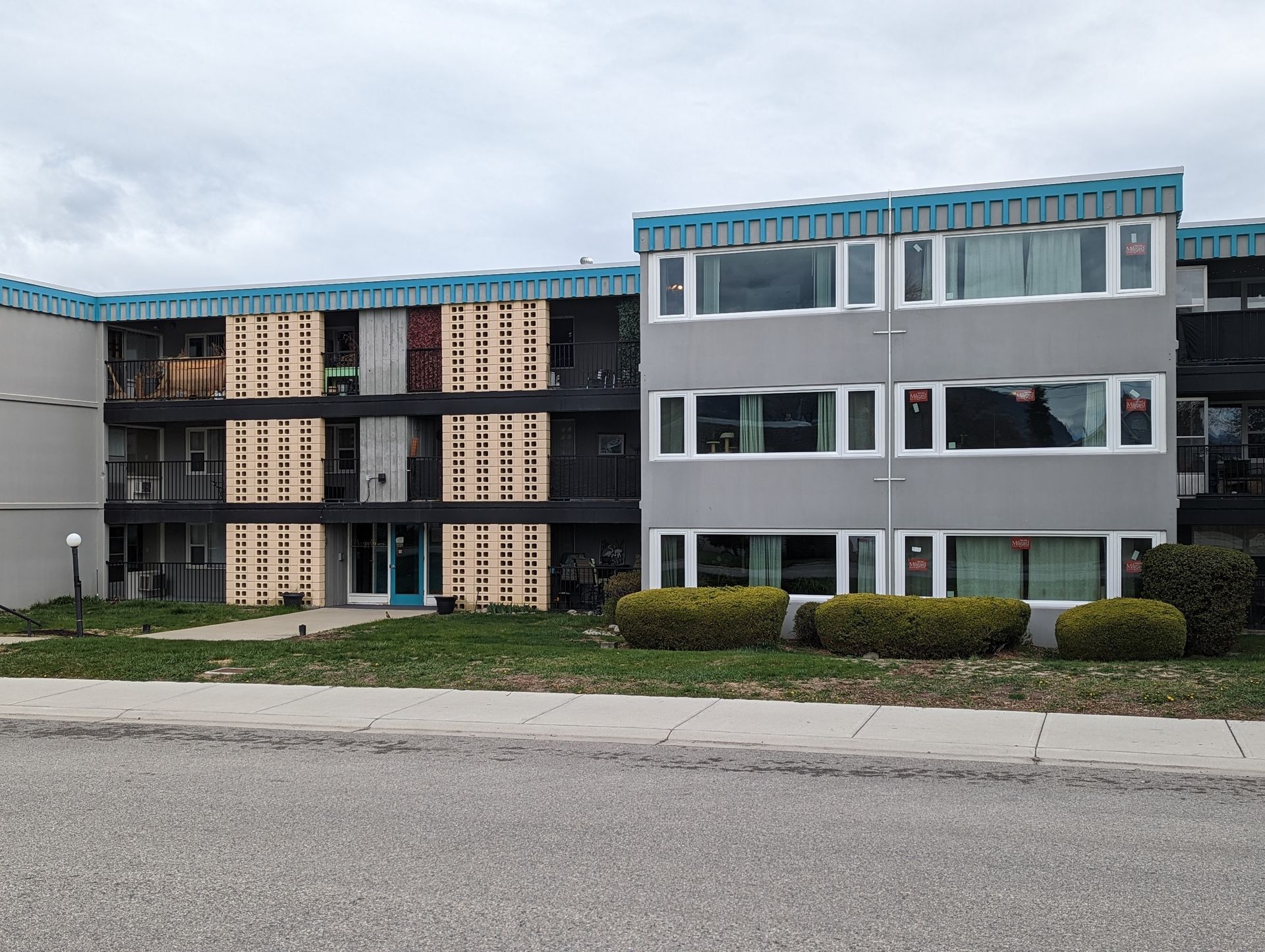A large apartment building with a lot of windows on a cloudy day.