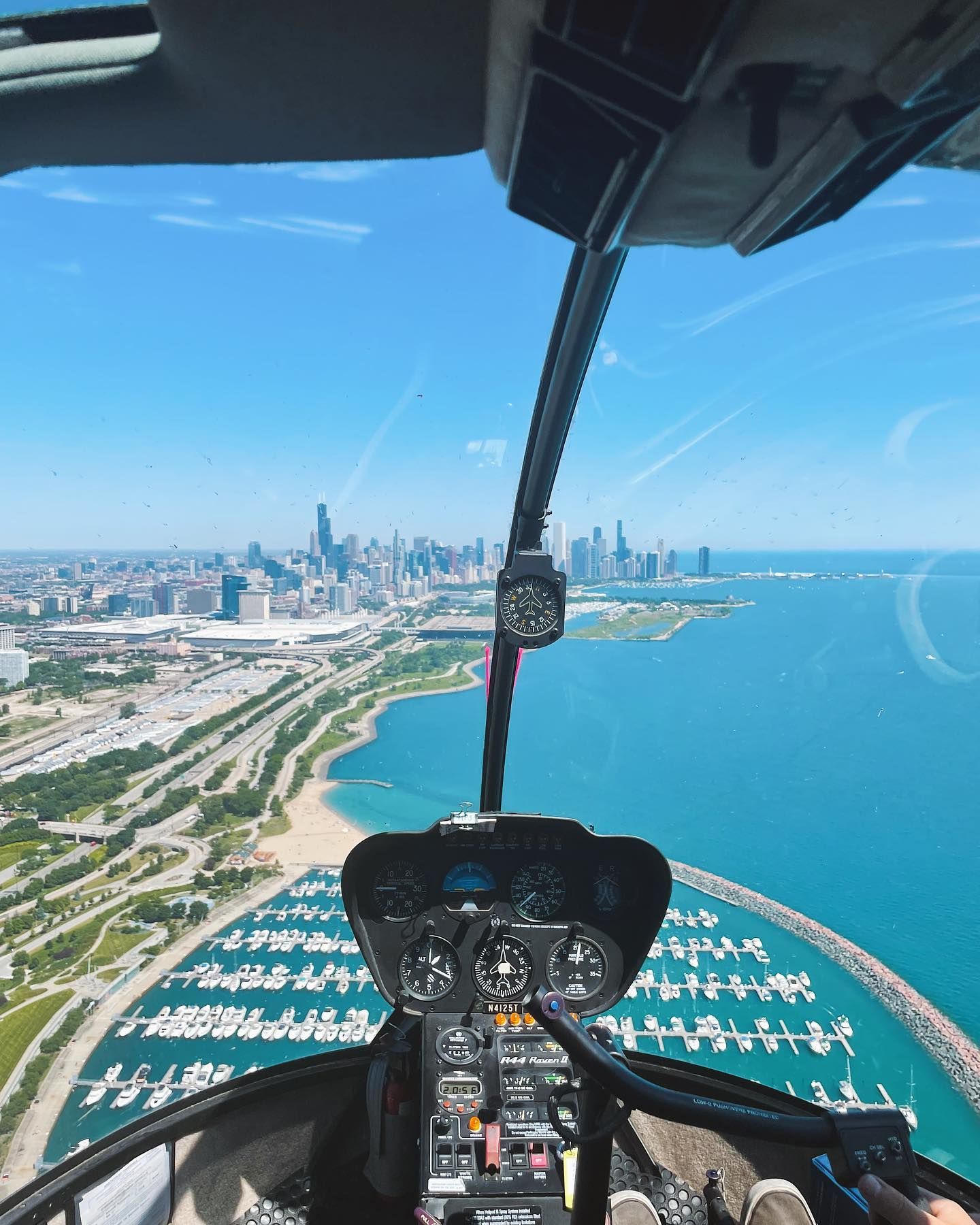 Helicopter view of Chicago skyline and Lake Michigan on a clear, sunny day.