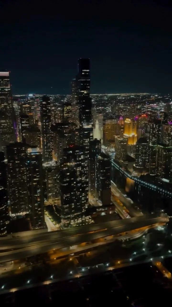 Night aerial view of Chicago skyline, illuminated buildings and roads.